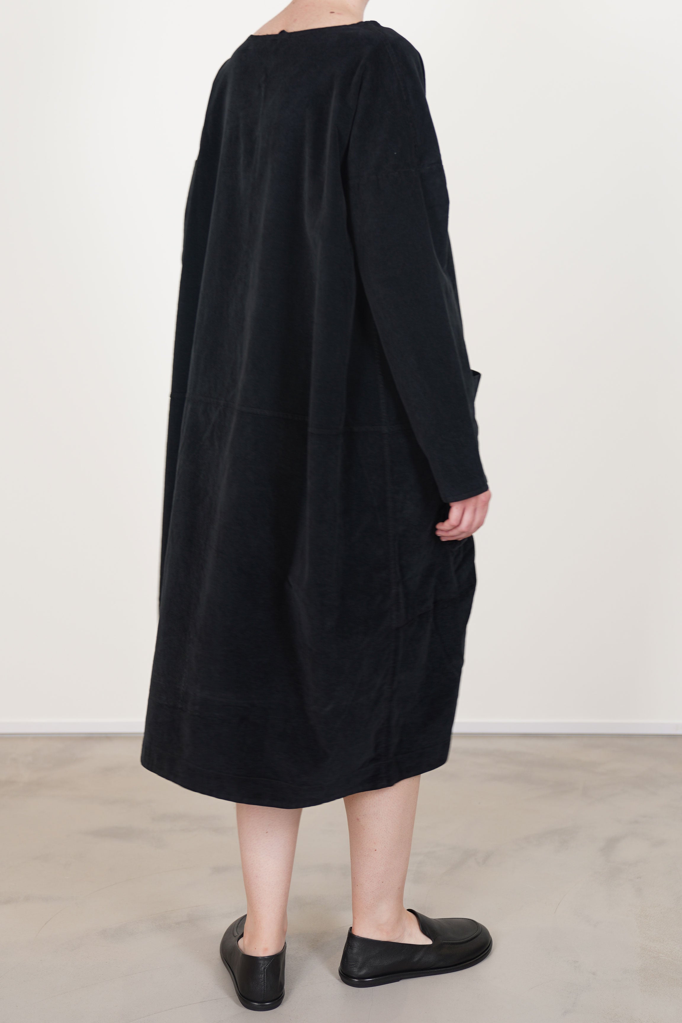 side view of album di famiglia dress tasche velvet black long sleeves, drop shoulders and midi length