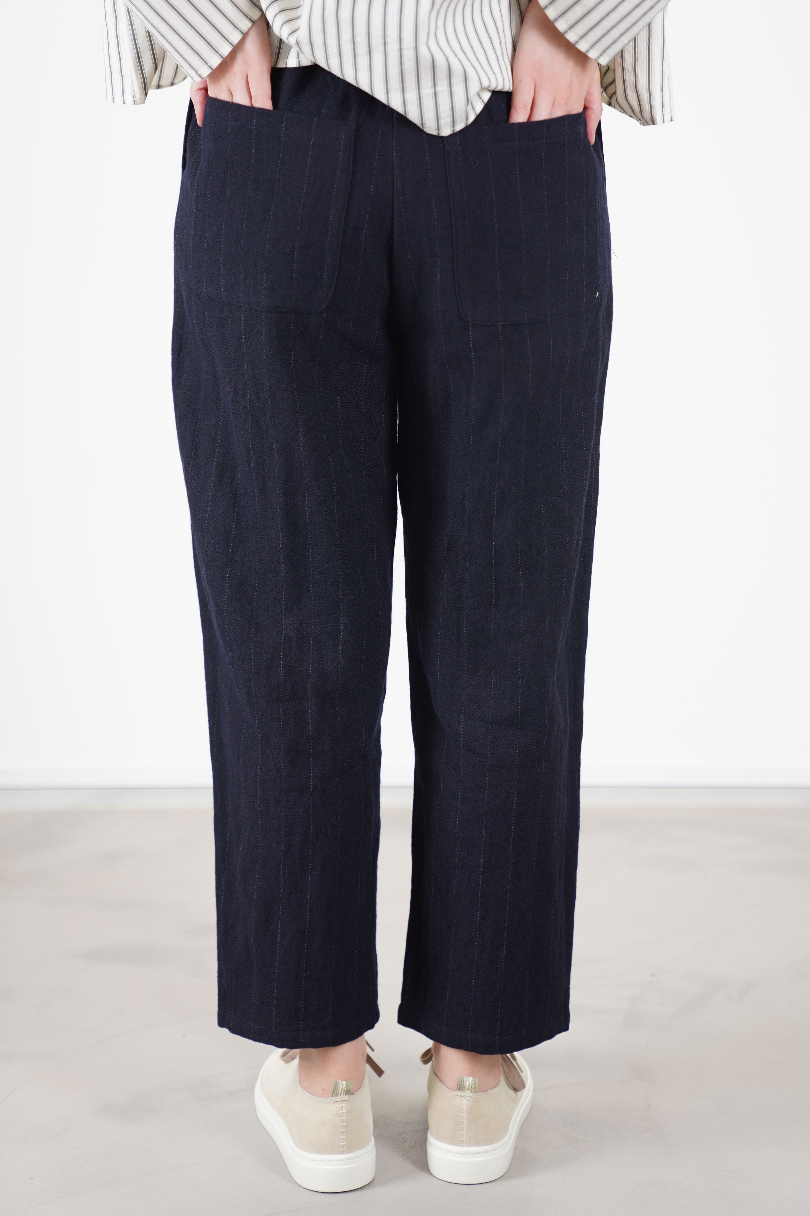 back view of apuntob (a.b) woolen trousers blue thin stripes with two back patch pockets that complete the design for comfort and functionality