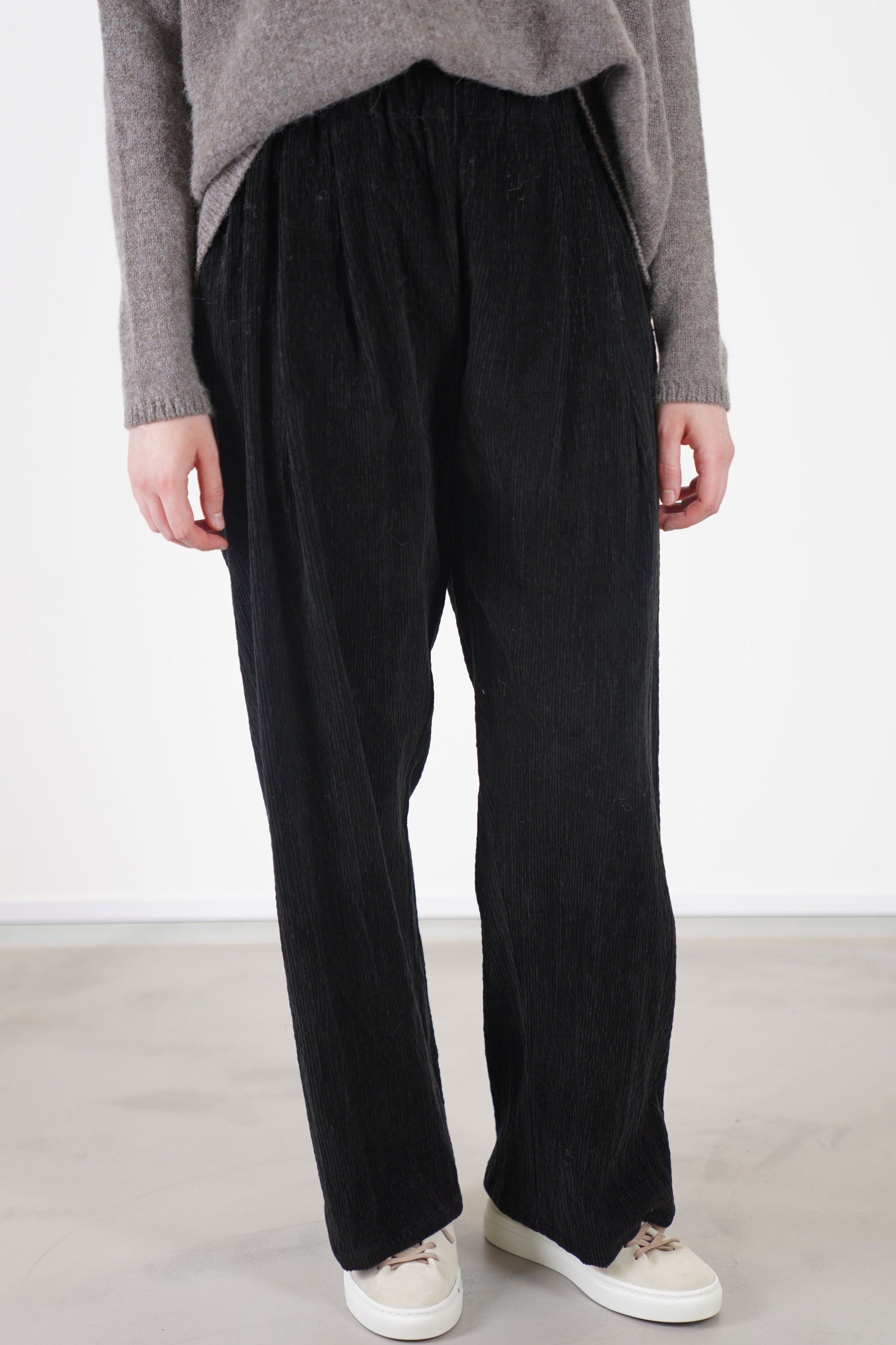 detail view of apuntob (a.b) trousers cord black designed with a wide-leg cut, and an elastic waistband for a comfortable, relaxed fit.