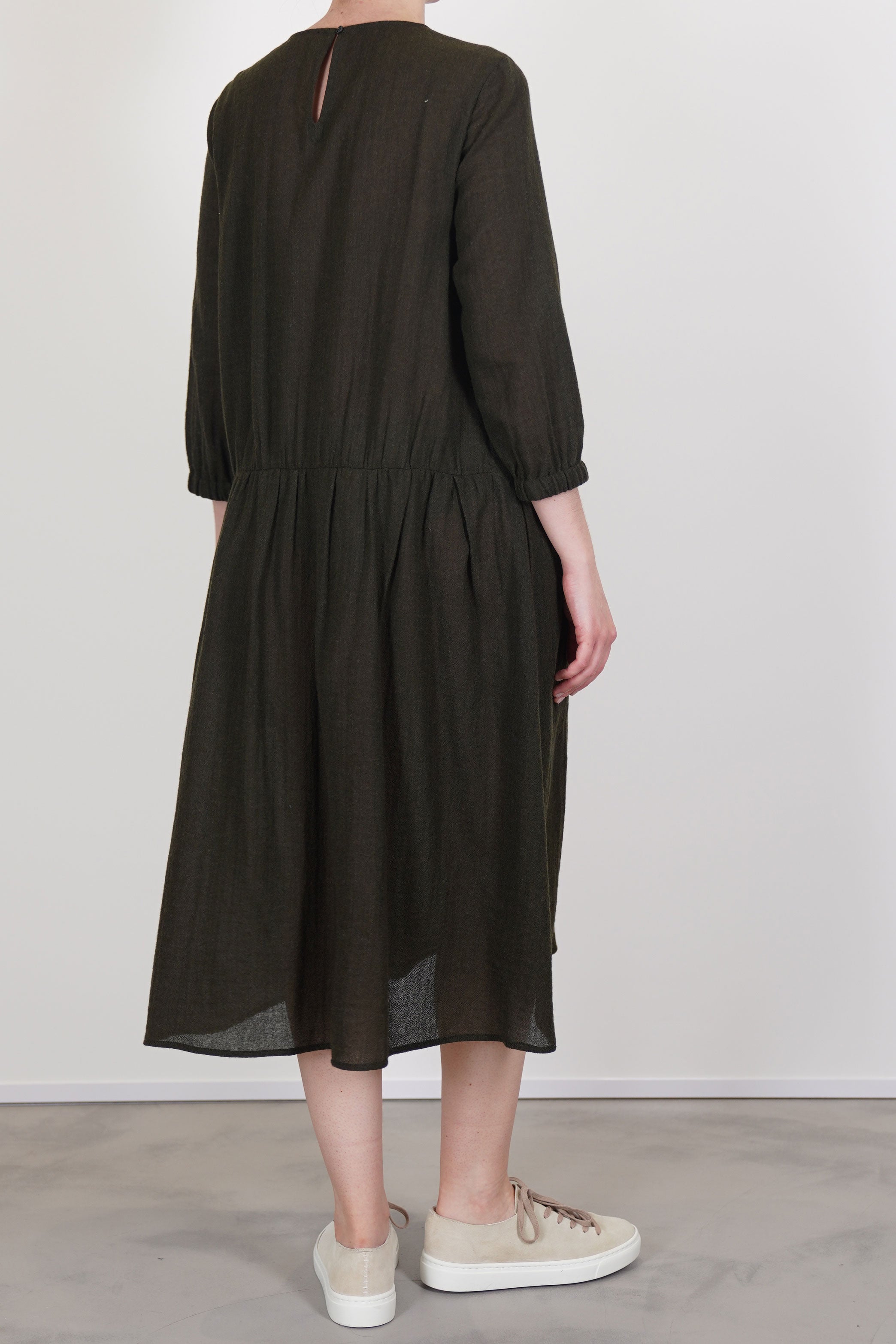 apuntob (a.b) wool dress in military green back closure with a discreet button at the neck adds a polished finish. unlined.