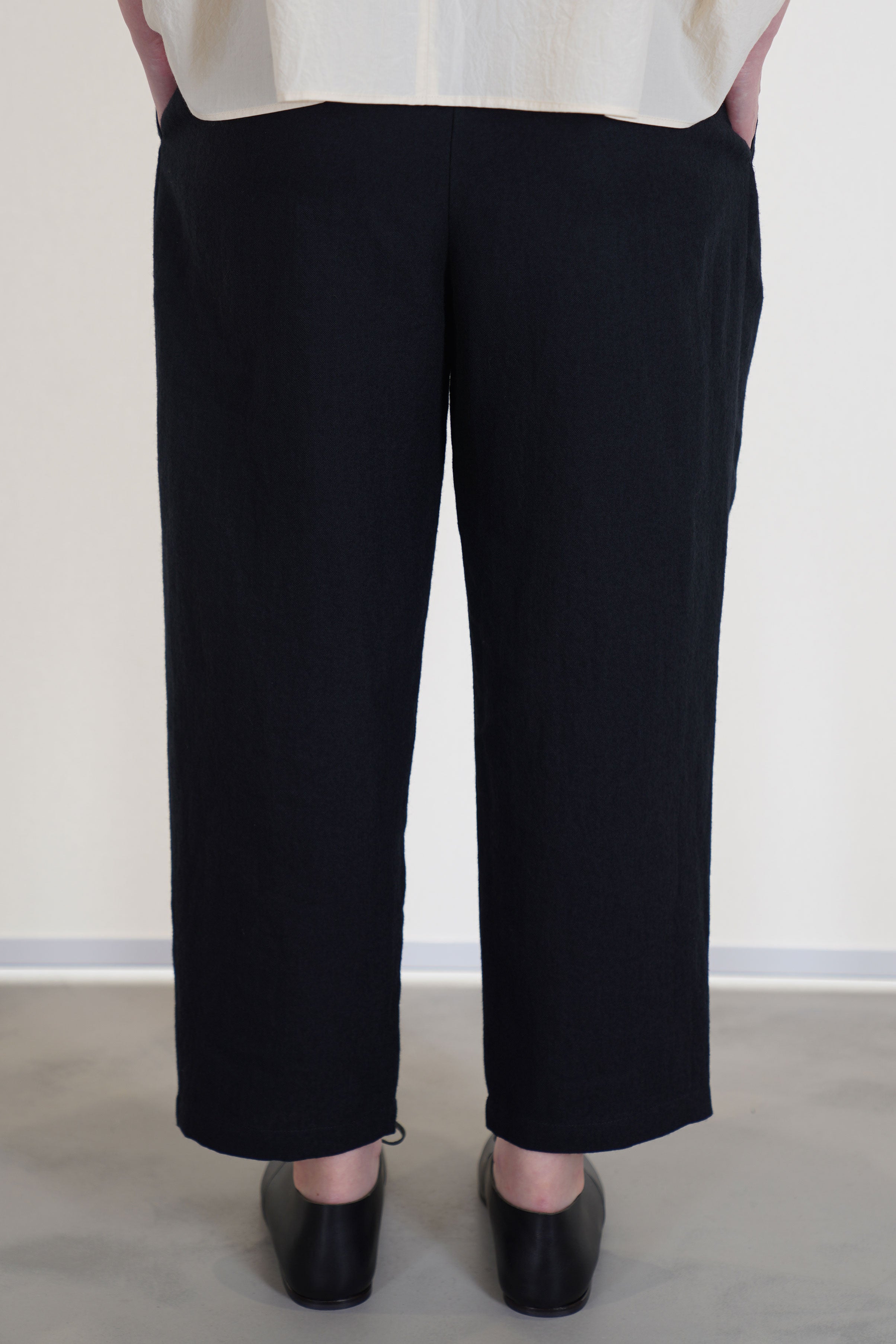 back view of apuntob (a.b) trousers black relaxed fit, slightly cropped length