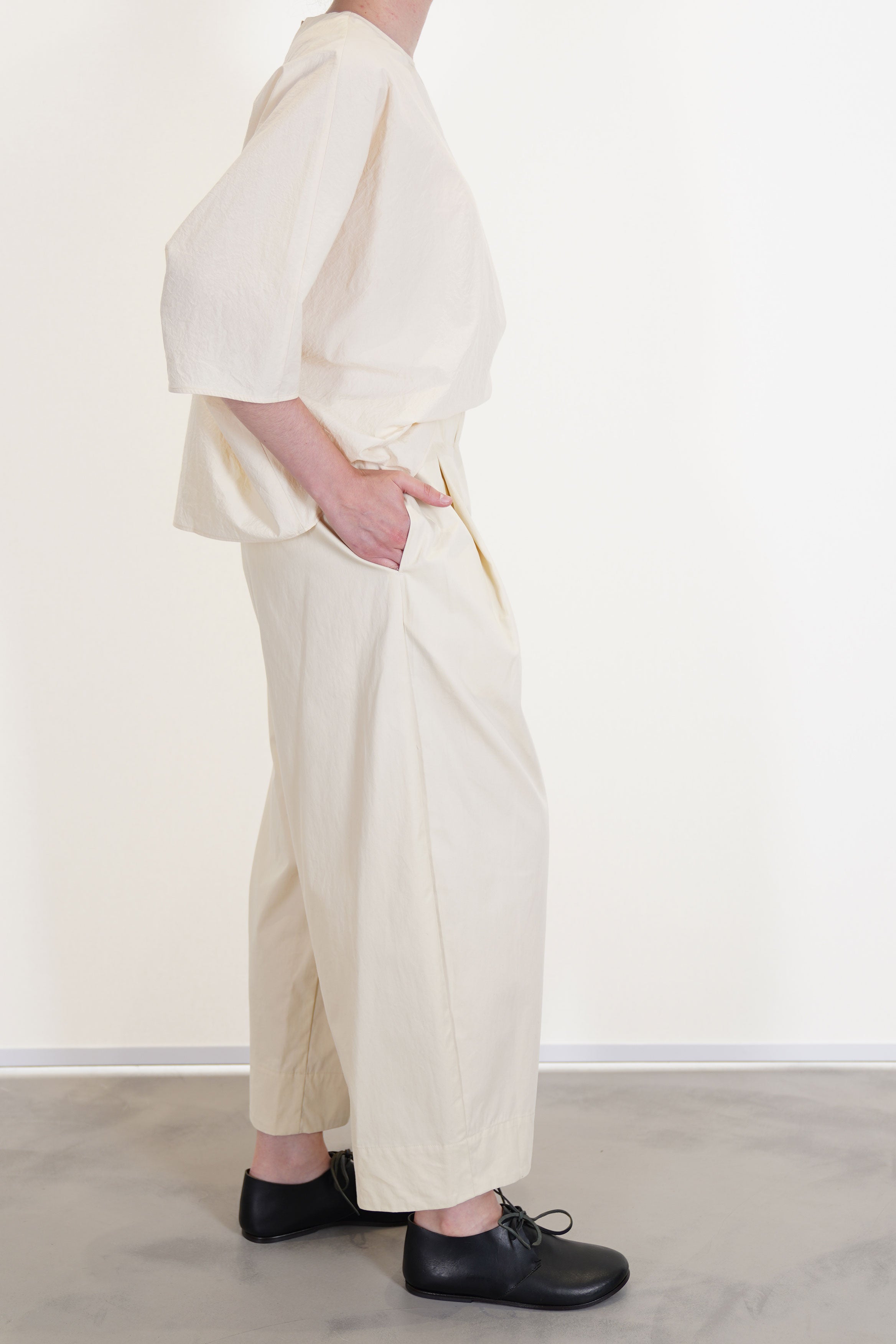 side view of apuntob (a.b) trousers natural paired with shirt natural in a relaxed fit