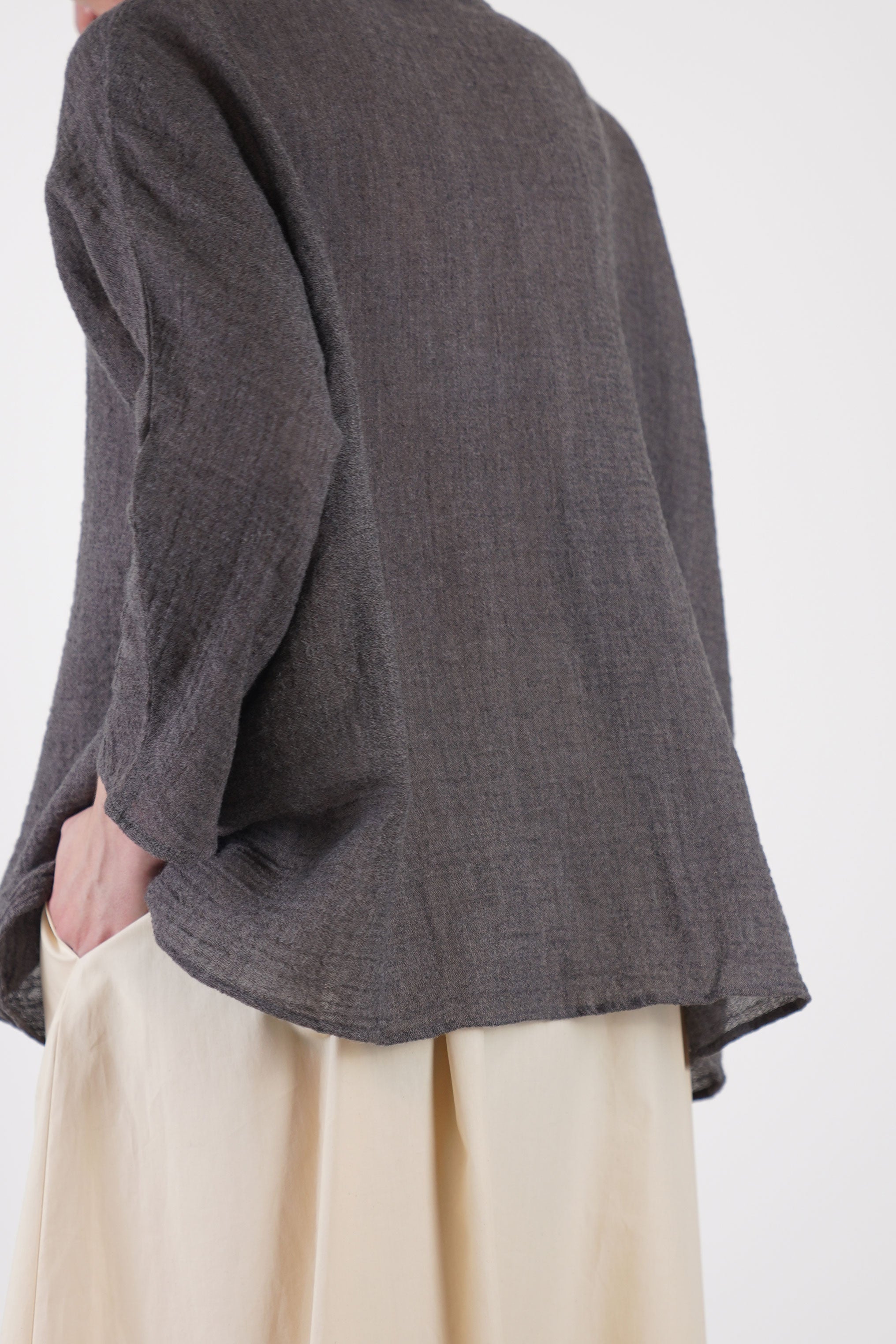 profile view of apuntob (a.b) linen wool shirt walnut featuring dropped shoulders and sleeves that extend just below the elbow