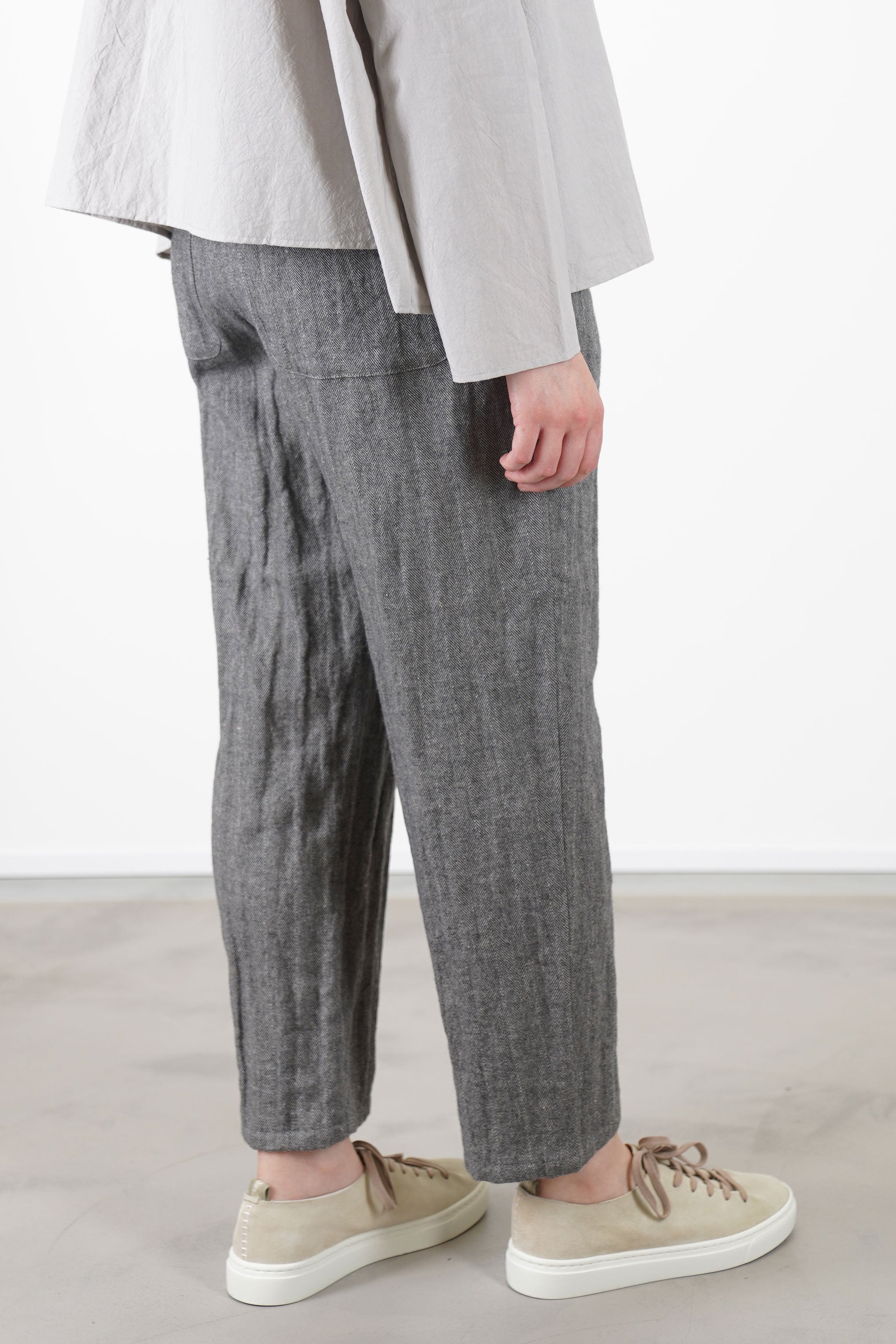 back view of apuntob (a.b) woolen trousers ecru stone relaxed fit with a tapered leg, and a slightly cropped length.