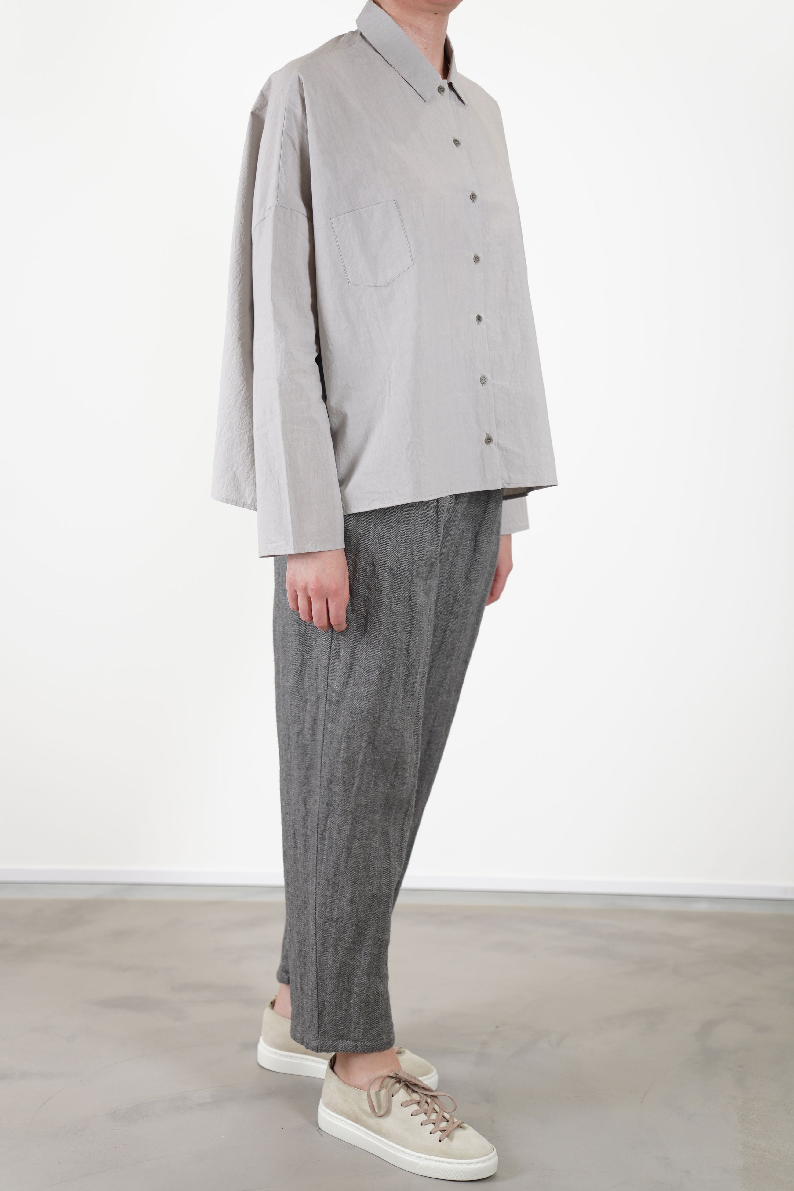 side view of apuntob (a.b) shirt light grey dropped shoulders, and slim, tailored sleeves for a refined fit.