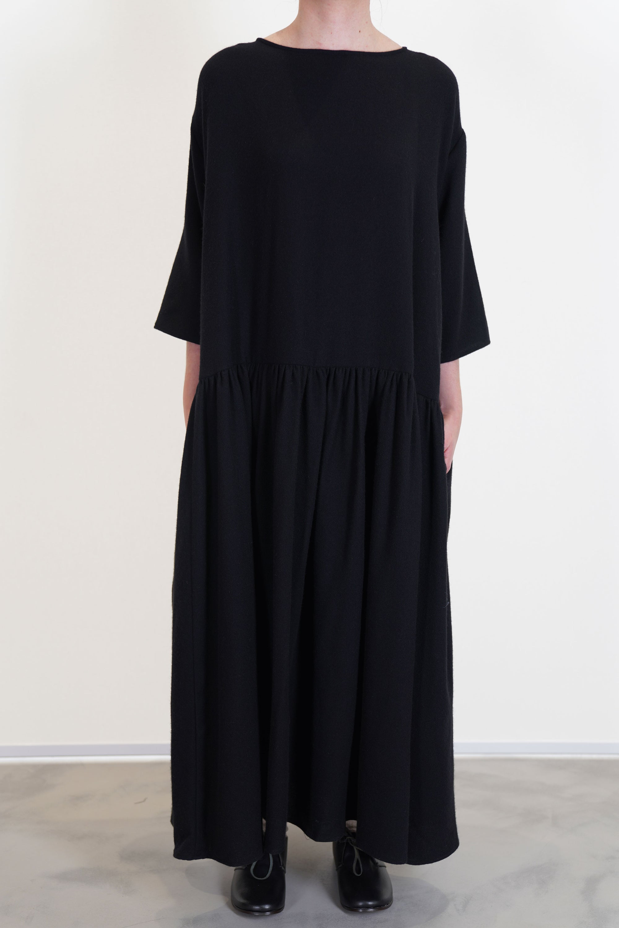 apuntob (a.b) dress black featuring a boat neckline, a wide and loose cut, gathered material along the waistline and pleated details at the skirt
