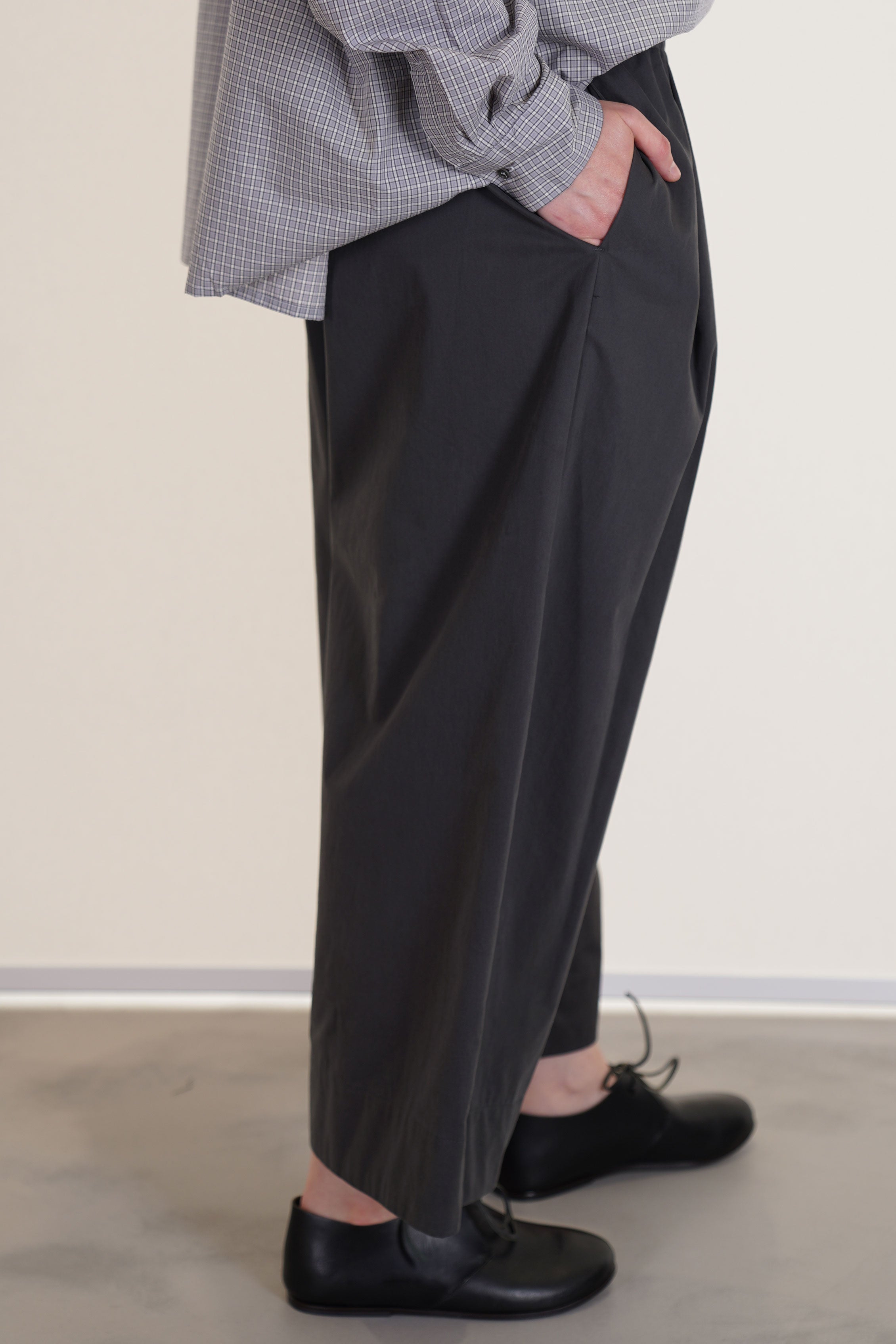 profile view of apuntob (a.b) trousers stone gathered material along the waistband and side pockets.