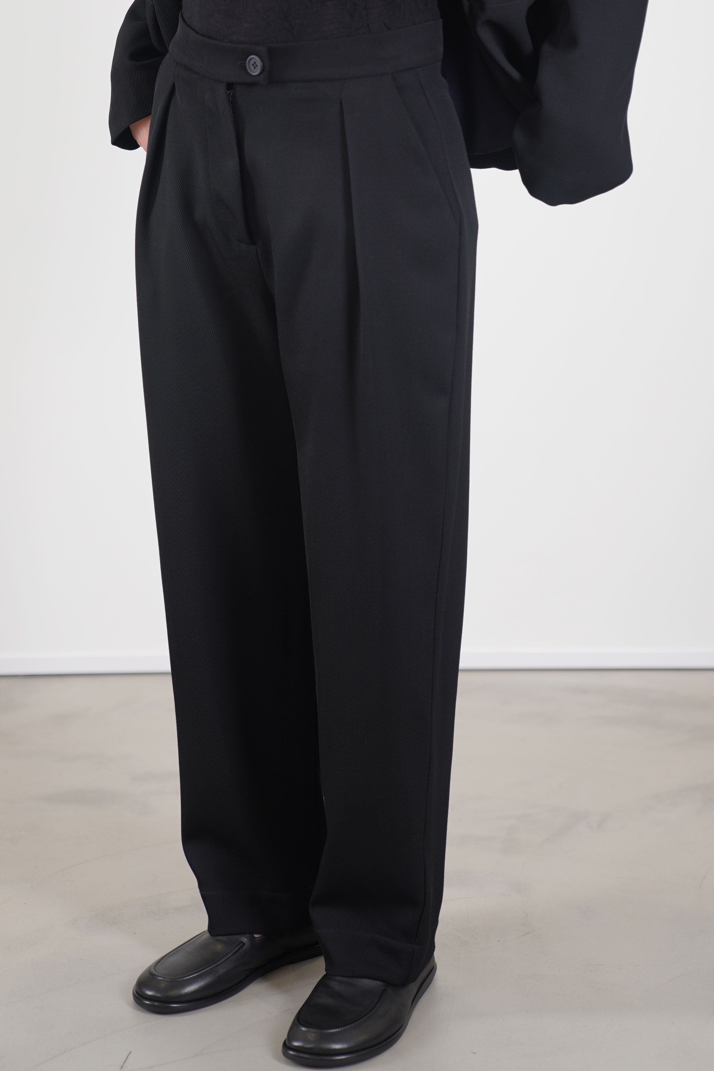 detail view of asciari trousers colette wool black showcase a ribbed texture, a high waist, and pleated accents