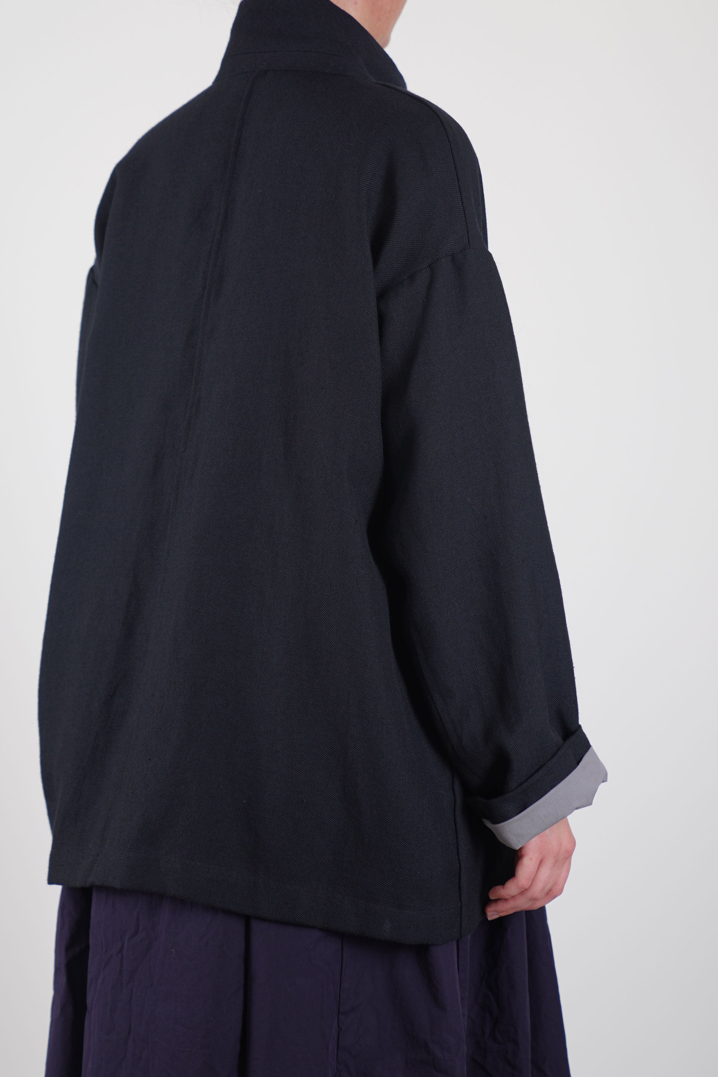 back view of bergfabel wool linen bella jacket black navy signature cotton lining for the sleeves only that provides a sophisticated and elegant finish.