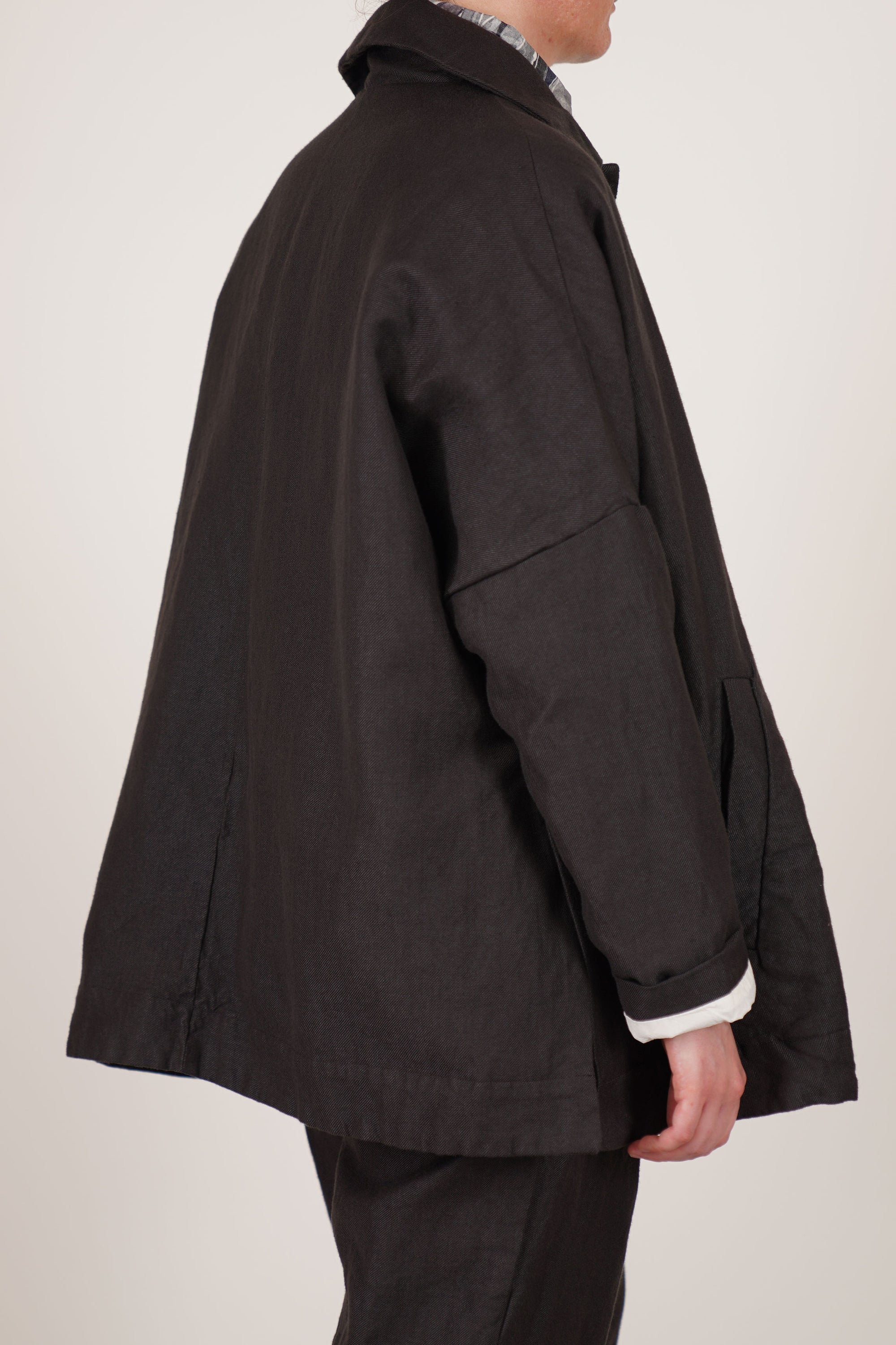 back view of casey casey sunny bab jacket dark brown long slim sleeves with drop shoulders and front slash pocket details.