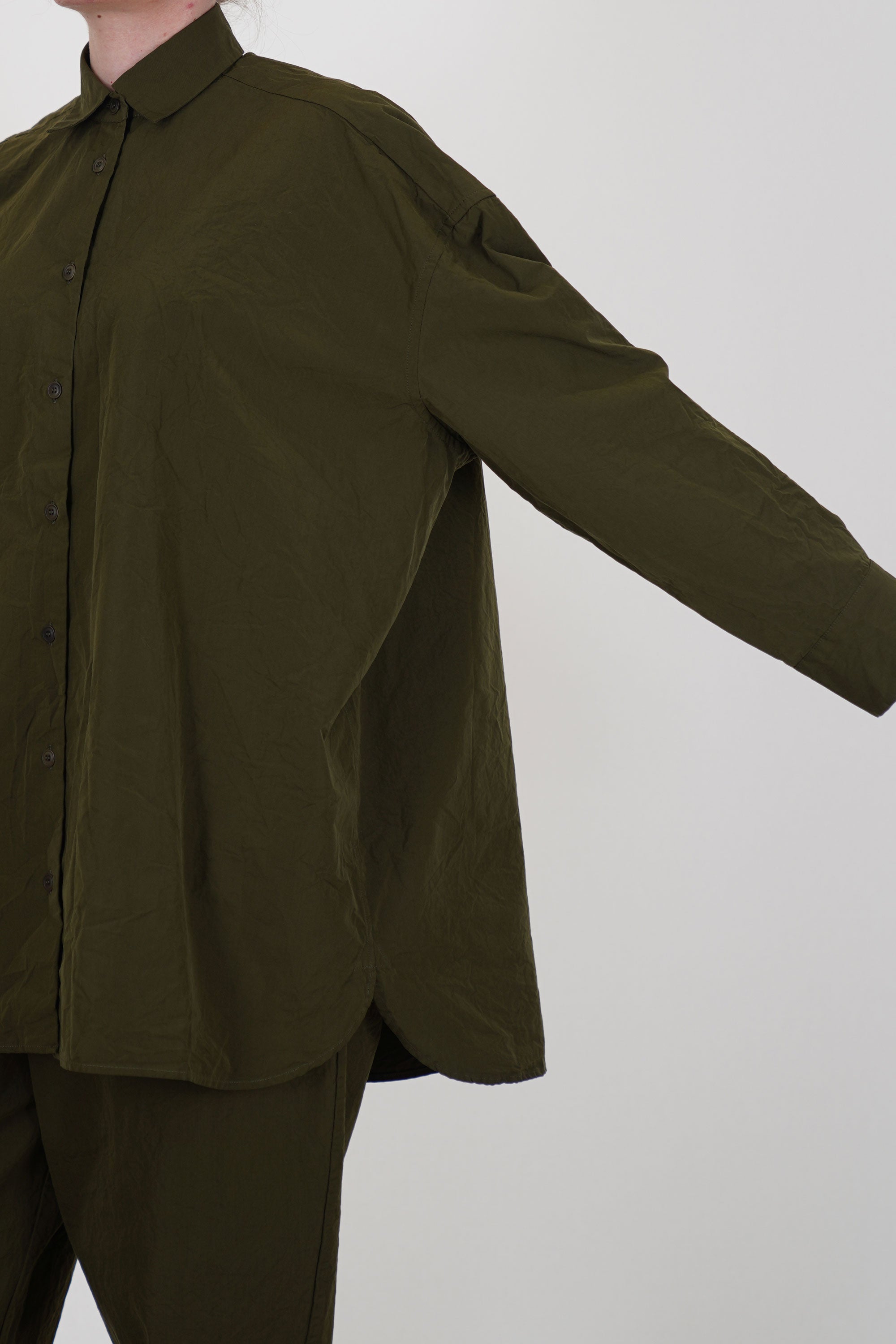 detail view of casey casey hamnet shirt green lake featuring a long sleeve, curved hemline and an elongated back for a relaxed and loose fit.