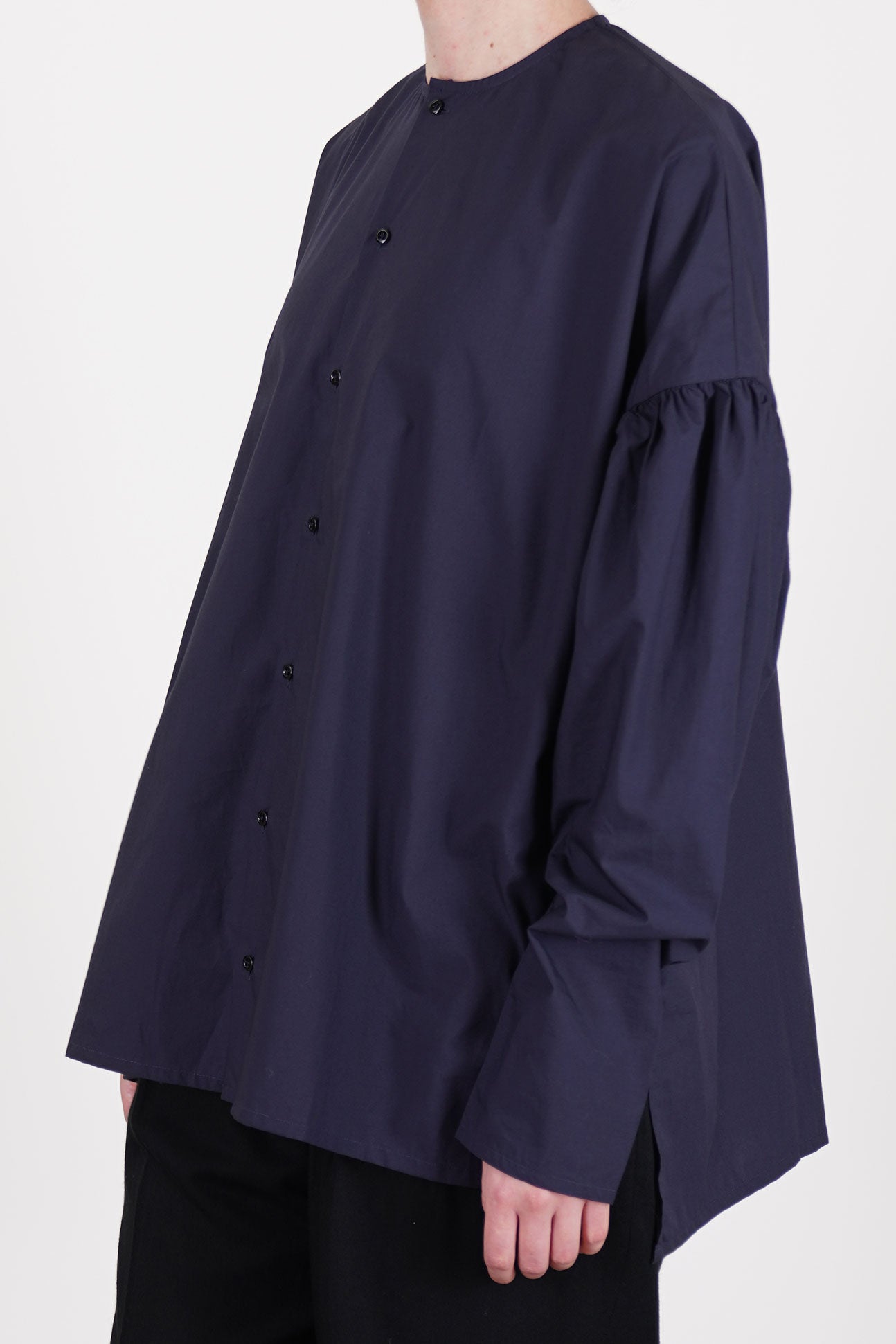 profile view of école de curiosités shirt basil dark navy dropped shoulders and voluminous long sleeves