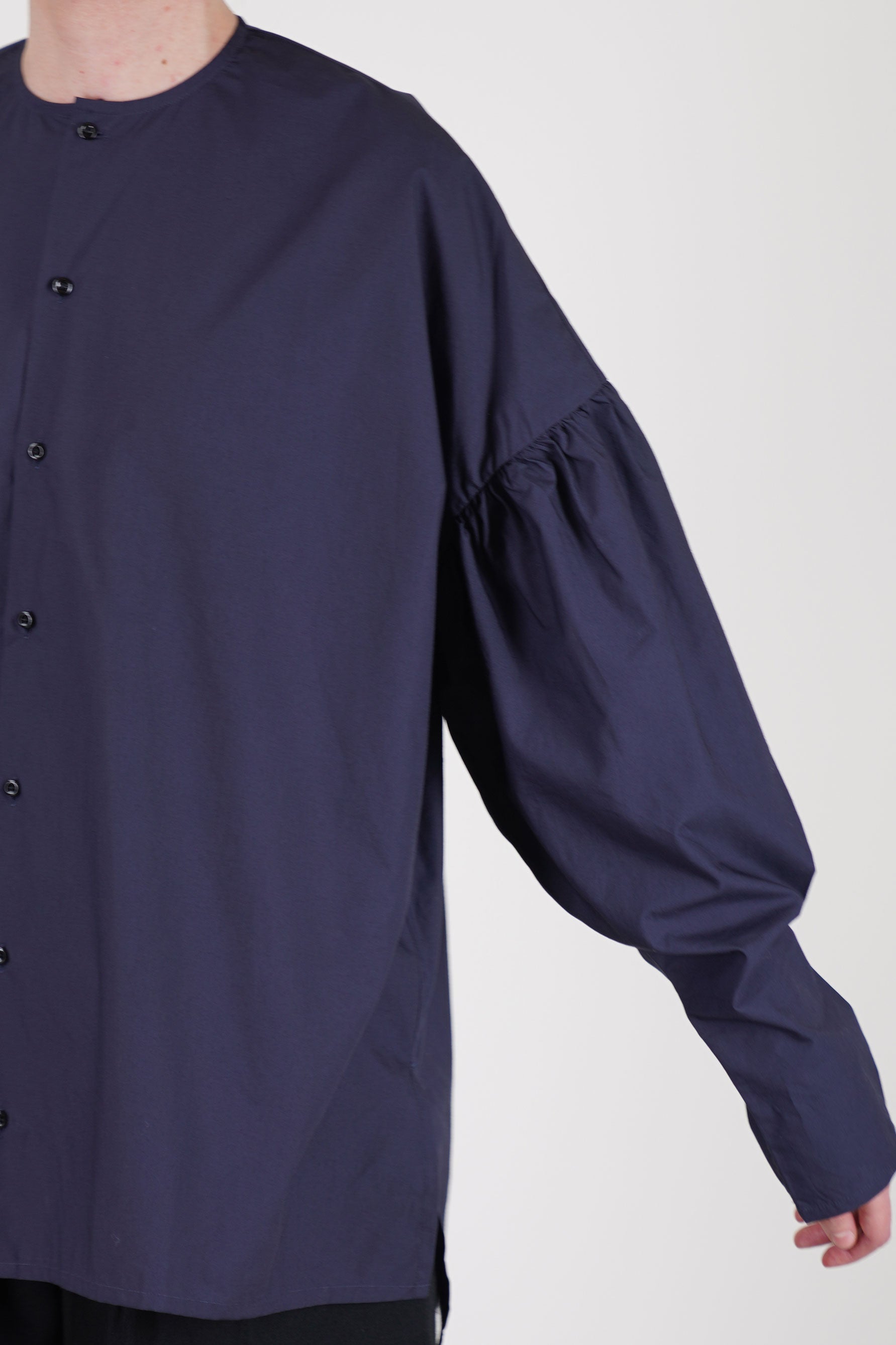 detail view of école de curiosités shirt basil dark navy relaxed silhouette, voluminous sleeves and side slit detail