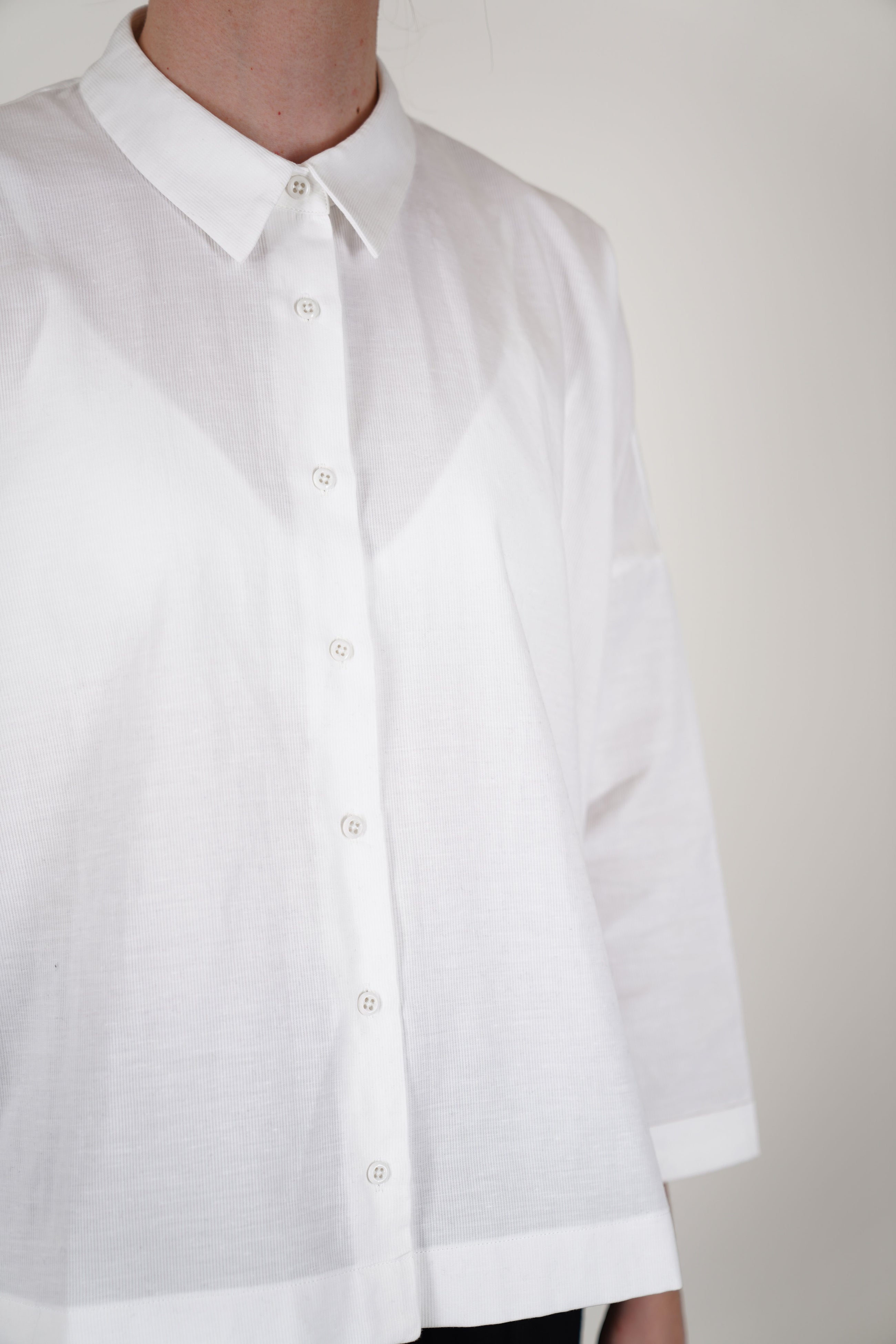 detail view of école de curiosités shirt brigitte piqué off-white made from textured, subtly ribbed cotton piqué fabric, it combines comfort with sophisticated craftsmanship.