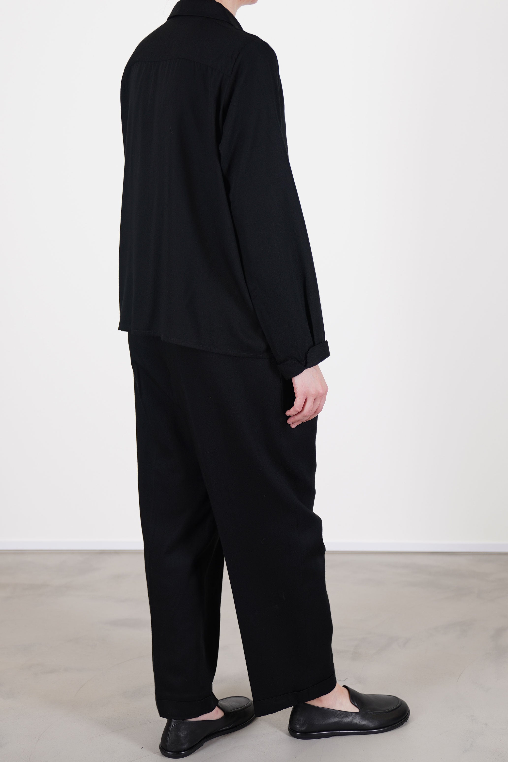 back view of école de curiosités shirt jacqueline black made from soft rayon twill, providing a smooth and graceful drape.