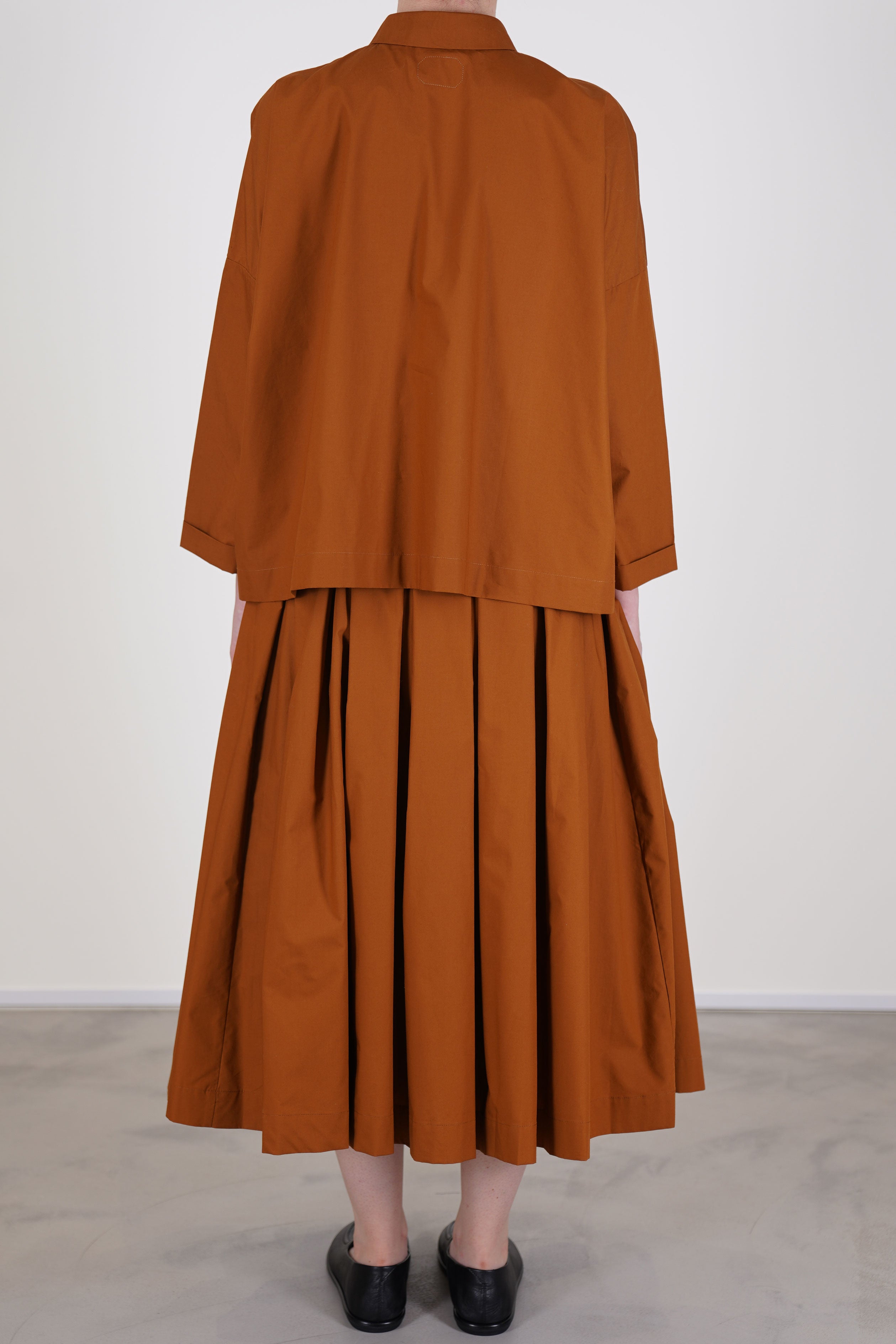 back view of école de curiosités skirt solange caramel brown constructed from lightweight typewriter cotton, it delivers a structured yet breathable texture and is fully lined.