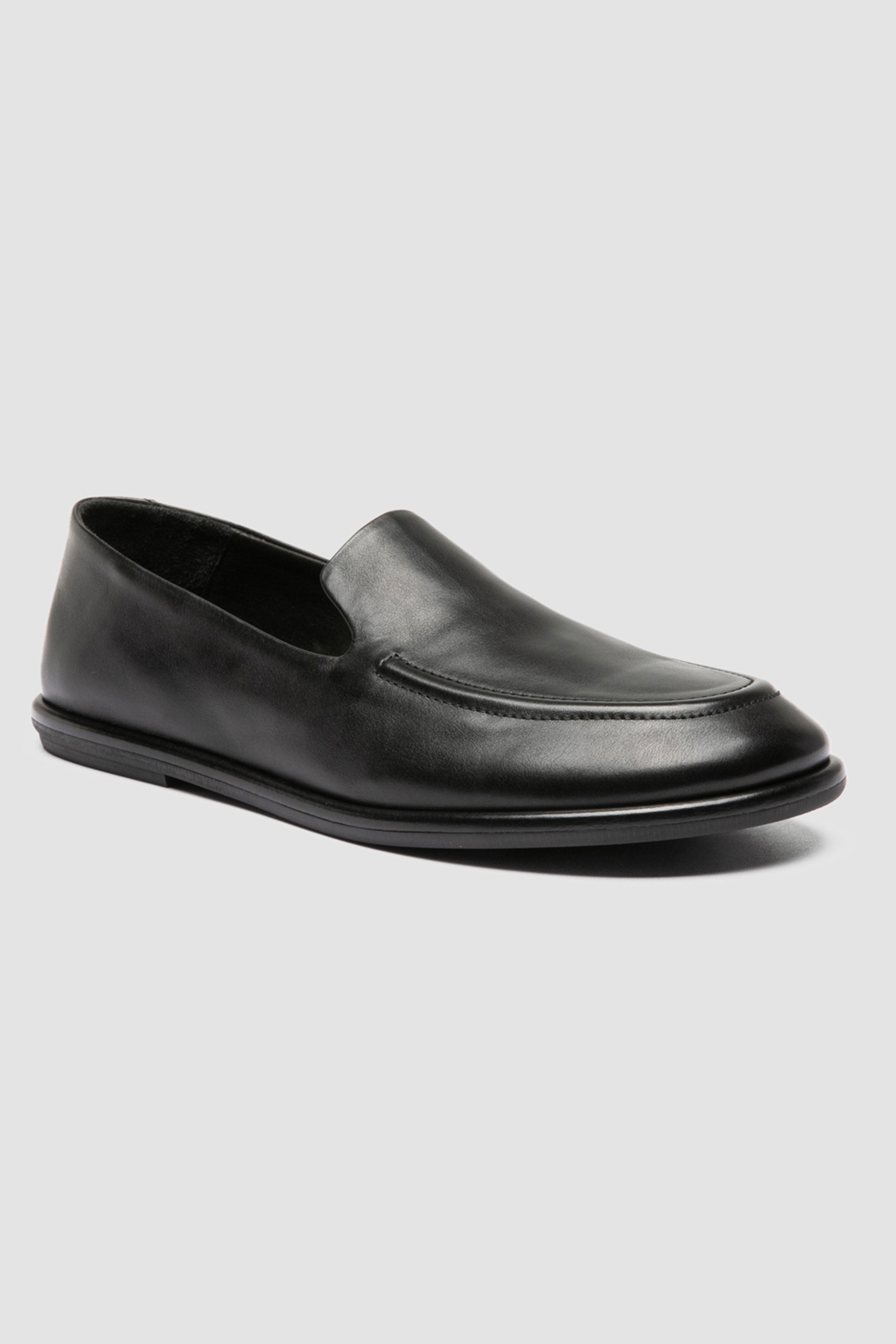 Close-up of Officine Creative Mienne 101 loafers in soft black leather, showcasing fine Italian craftsmanship and minimalist rubber sole design.