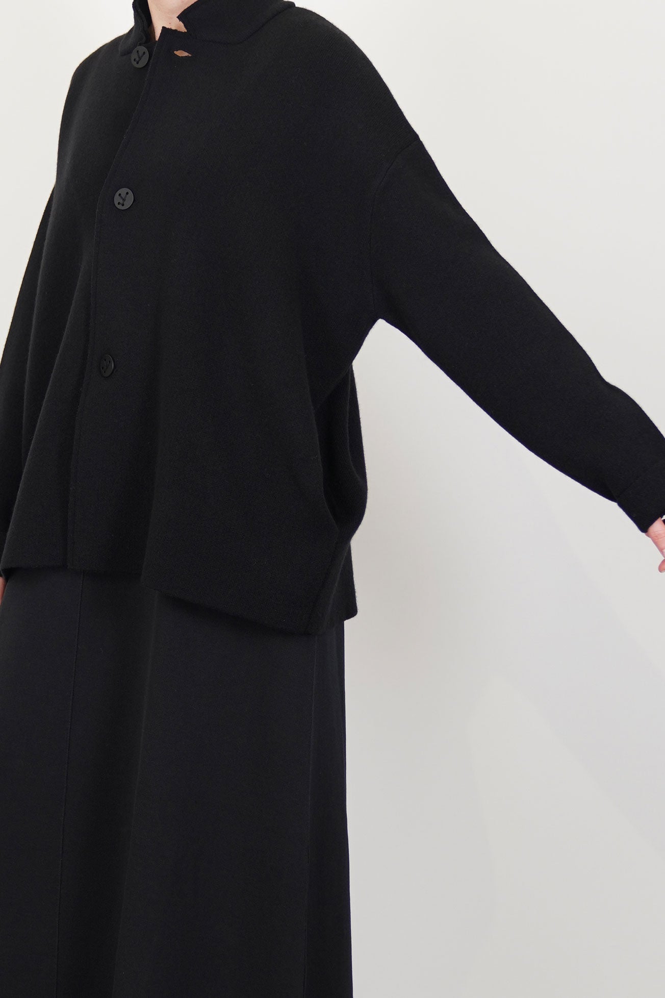 profile view of oyuna wind knitted jacket cashmere black drop shoulders and long sleeves