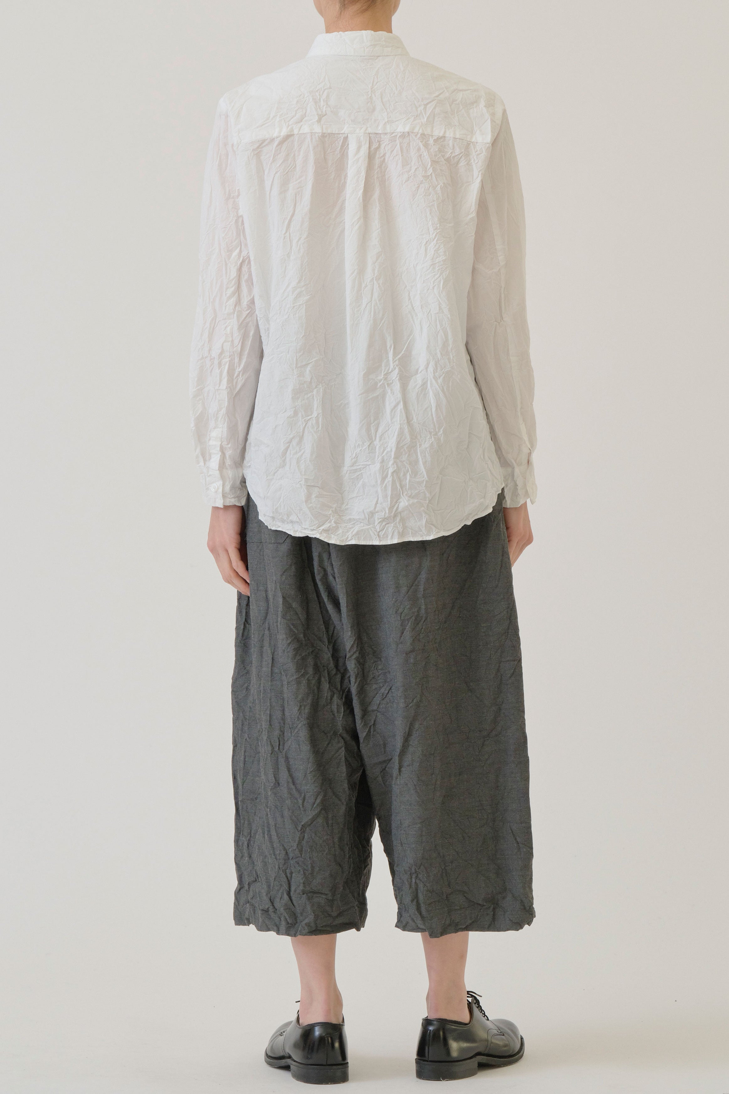 back view of pas de calais cotton typewriter blouse white single back pleat detail and a curved hemline.