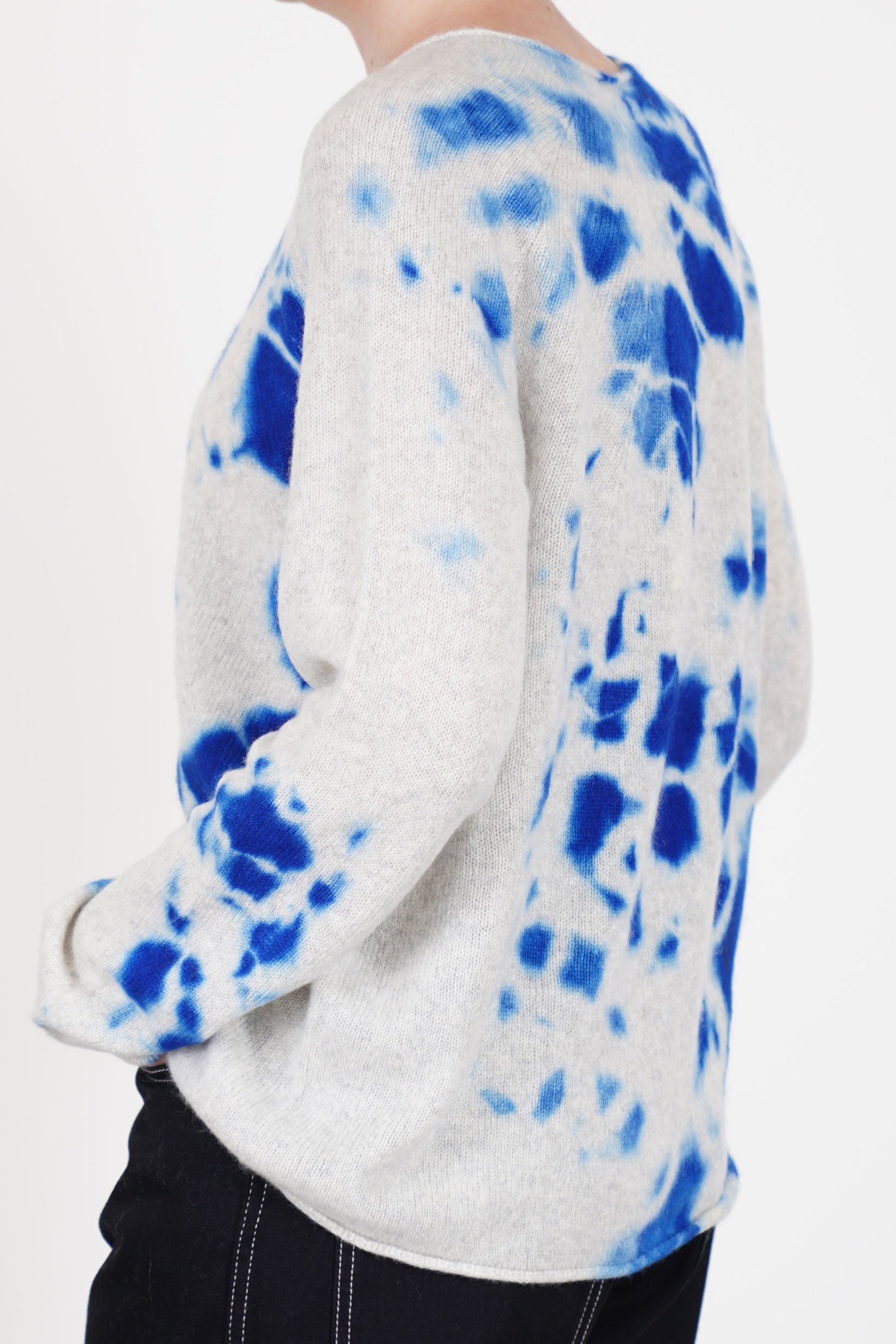 profile view of suzusan cashmere seamless pullover long royal blue light grey rolled up details at the hemline and cuffs.