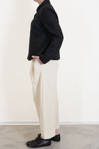 detailed view of apuntob (a.b) jacket black worn with trousers natural minimalist and slow fashion outfit