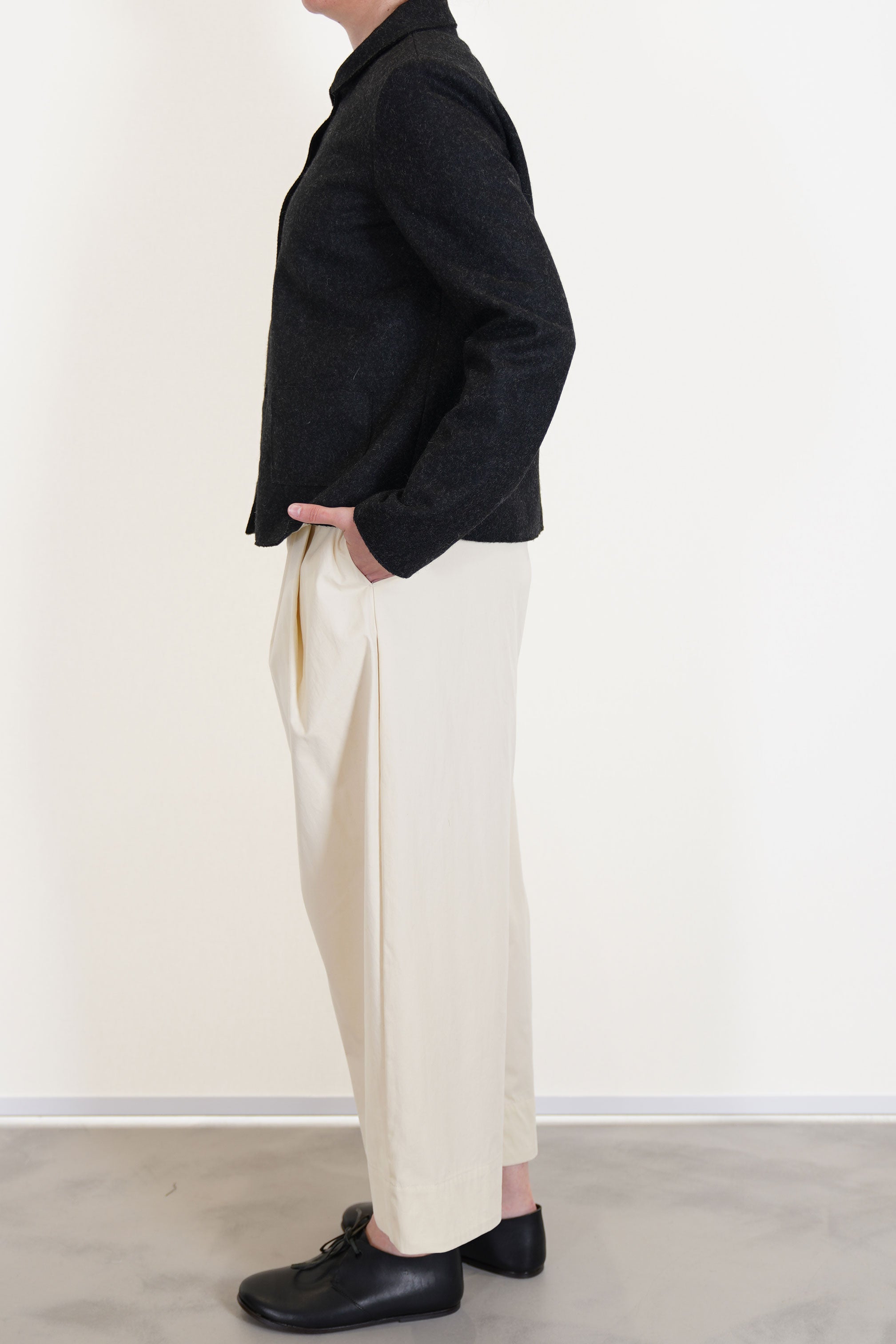 detailed view of apuntob (a.b) jacket black worn with trousers natural minimalist and slow fashion outfit