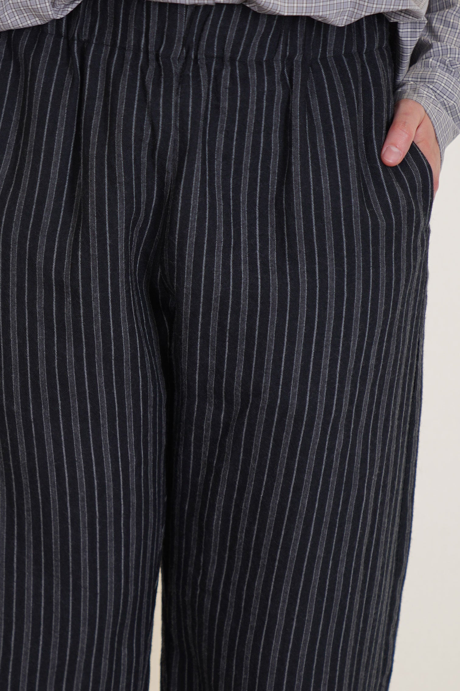 detail view of apuntob (a.b) trousers stripes black elasticated waistband, side pockets.