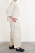 side view of apuntob (a.b) trousers natural paired with shirt natural in a relaxed fit