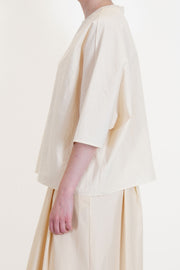 side view of apuntob (a.b) shirt natural elbow length sleeves and drop shoulders in a wide and relaxed fit.