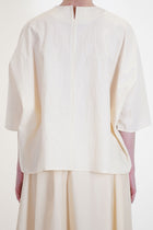 back view of apuntob (a.b) shirt natural featuring a round neckline with a slit detail at the back neckline. 