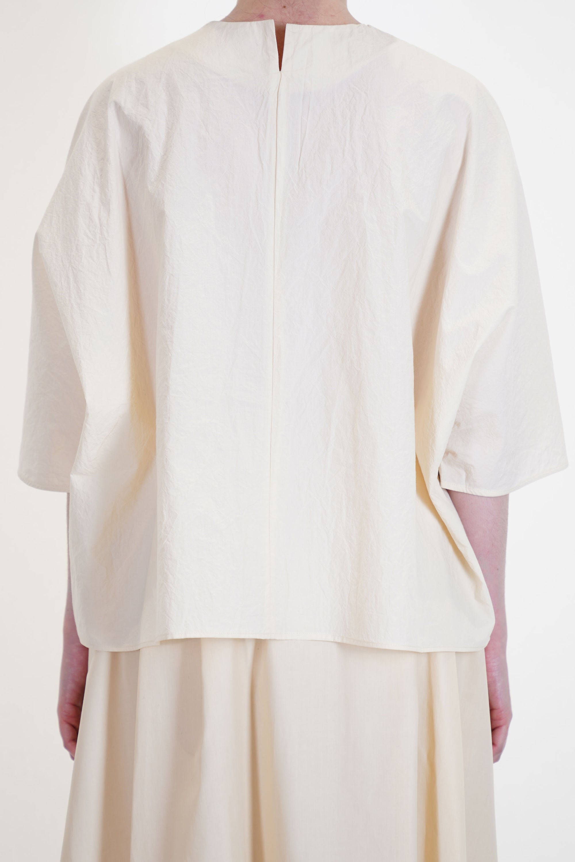 back view of apuntob (a.b) shirt natural featuring a round neckline with a slit detail at the back neckline. 