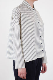 side view of apuntob (a.b) shirt cotton silk stripe natural black dropped shoulders, and slim, tailored sleeves for a refined fit.