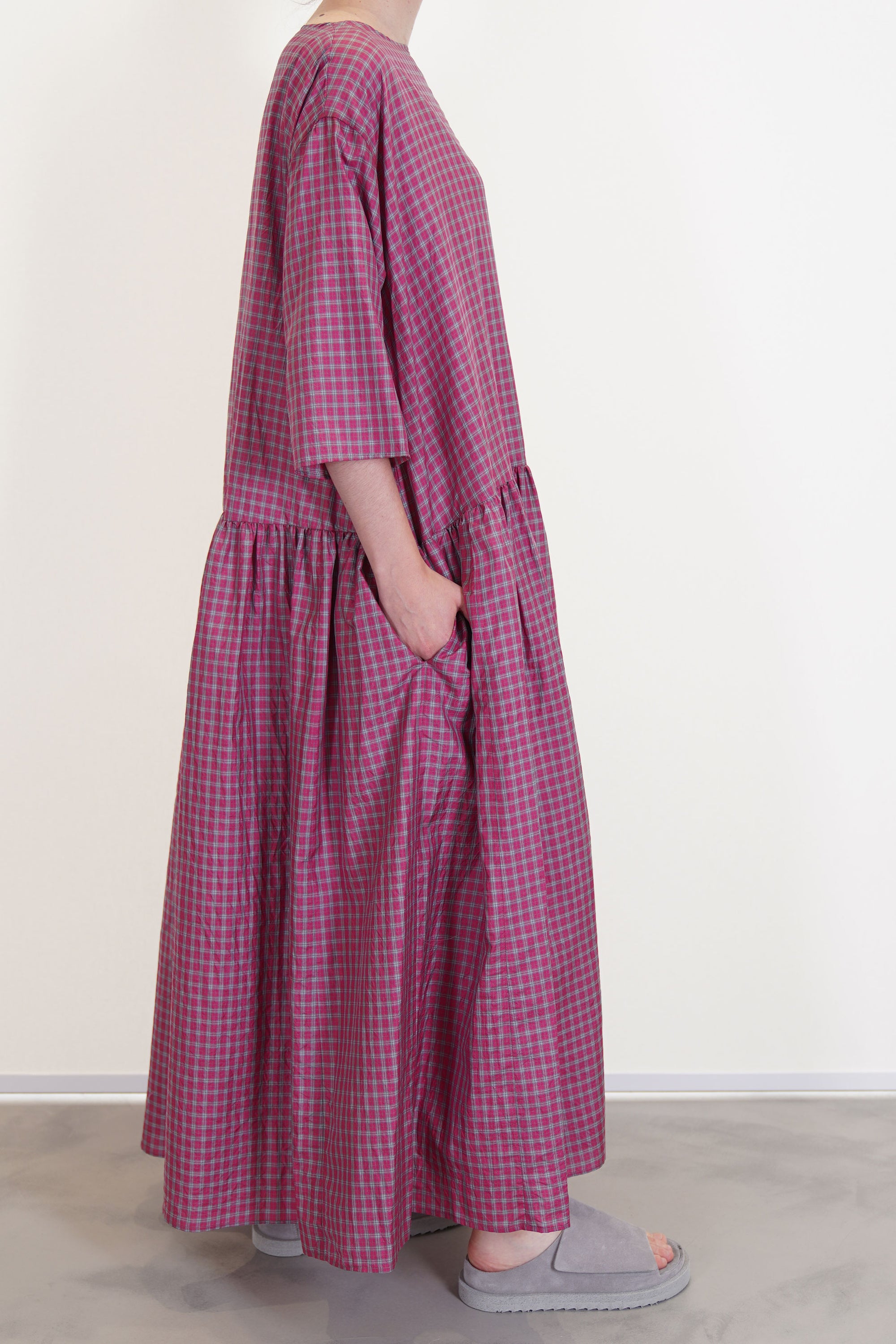 side view of apuntob (a.b) dress raspberry drop shoulders with elbow length sleeves and side pockets.