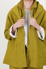 detail view of apuntob (a.b) jacket oil button front openingand hood string details