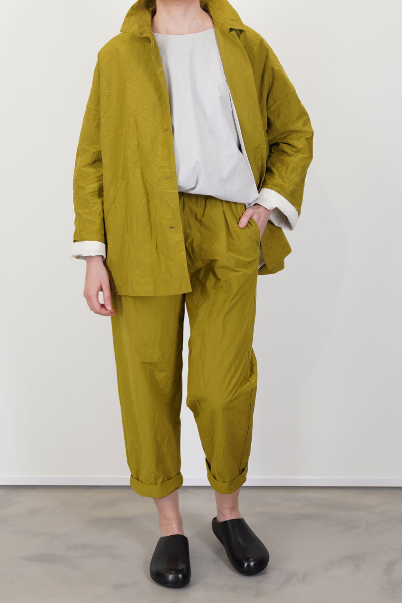 model wearing apuntob (a.b) jacket oil  with matching trousers for understated minimalist sihouette