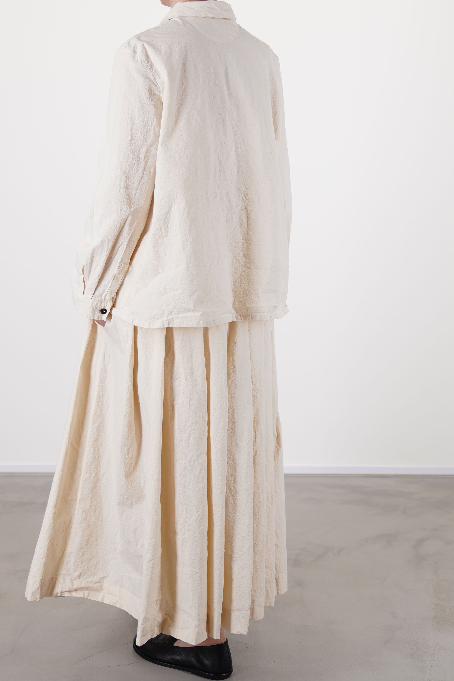 profile view of bergfabel matilde skirt off-white worn with jenny shirt off-white  offering a modern balance of color and shape.