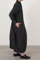 side view of bergfabel letty dress moss  featuring a slimmer fit on the top, slightly raised waist and a balloon style skirt with side pockets