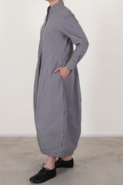 side view of bergfabel letty dress fog featuring a slimmer fit on the top, a half pannel front button opening