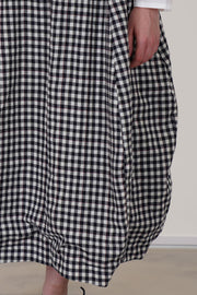 bergfabel virgin wool carla skirt check patter in a soft navy-off-white and thin red lined pattern, intentionally gathered material at the bottom 