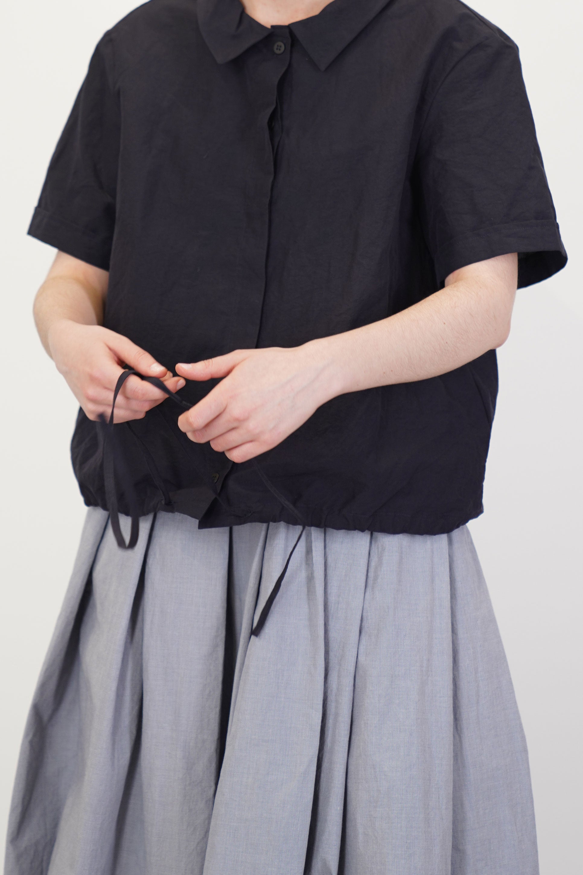 detail view of bergfabel alma shirt cotton linen black adjustable drawstrings at the hemline