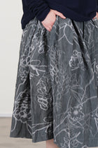 side view of casey casey double rideaux skirt ikat grey 'grey floral' print - with a washed out effect - characteristic of the IKAT fabric. 