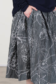 side view of casey casey double rideaux skirt ikat grey 'grey floral' print - with a washed out effect - characteristic of the IKAT fabric. 