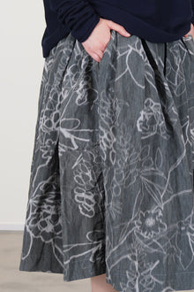 side view of casey casey double rideaux skirt ikat grey 'grey floral' print - with a washed out effect - characteristic of the IKAT fabric. 