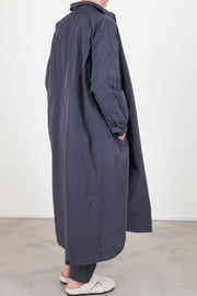 back view of casey casey yuki dress blu skull worn as an overcoat, side pocket details and paired with matching tippy pants