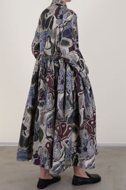 back view of casey casey stephanie dress print browns features a  skirt that gains gentle fullness from gathering beneath the waist, complemented by dropped shoulders and buttoned cuffs for a tailored yet relaxed fit. This piece is detailed with a full underskirt, a straight hem, and two concealed in-seam pockets for practicality. crafted from washed cotton, it offers a soft touch and unique character. the exclusive fl