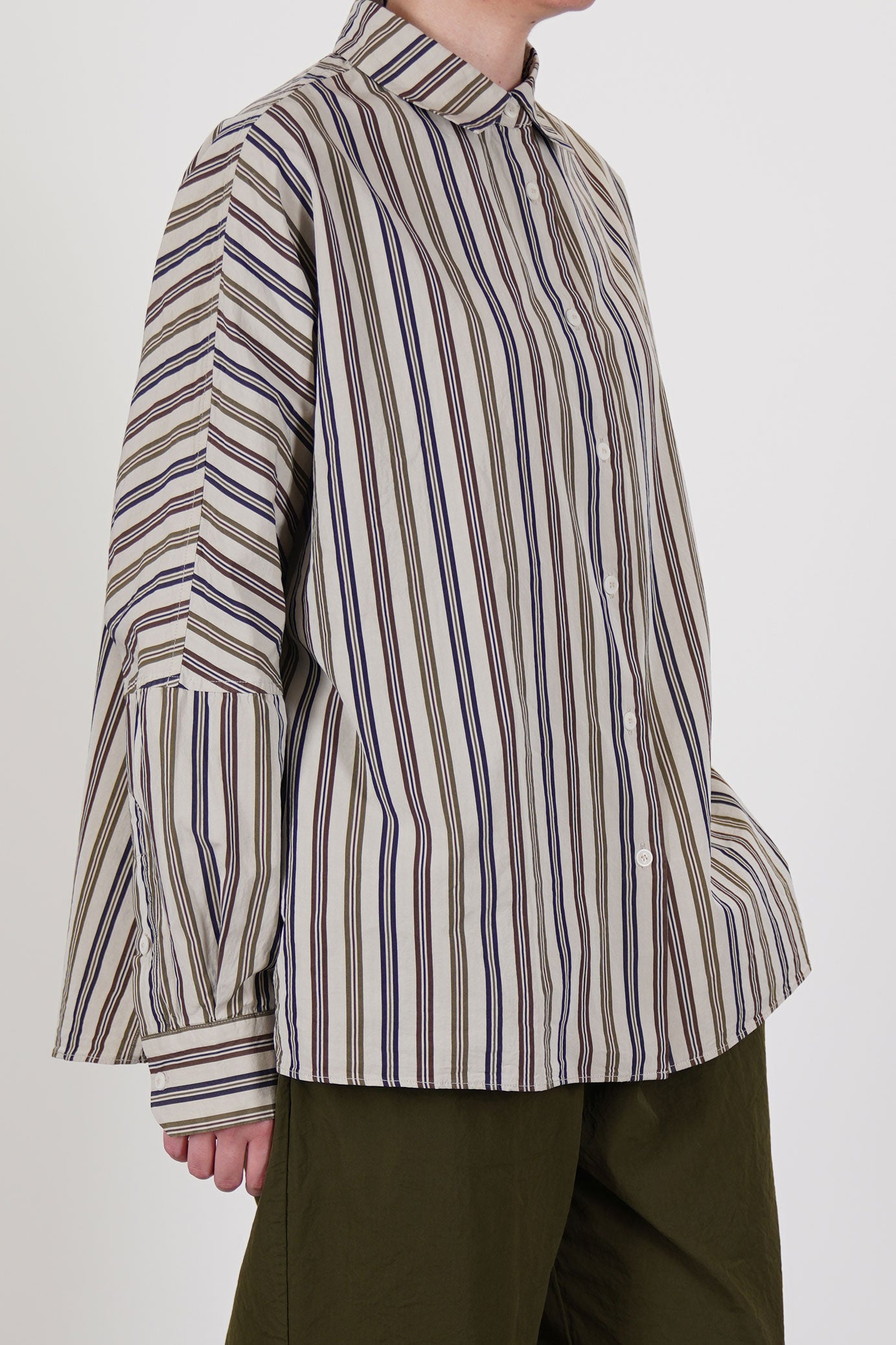 side view of casey casey waga shirt as is n°4 featuring a washed finish, dolman sleeves that are tapered towards the cuffs and a slightly curved hemline. 