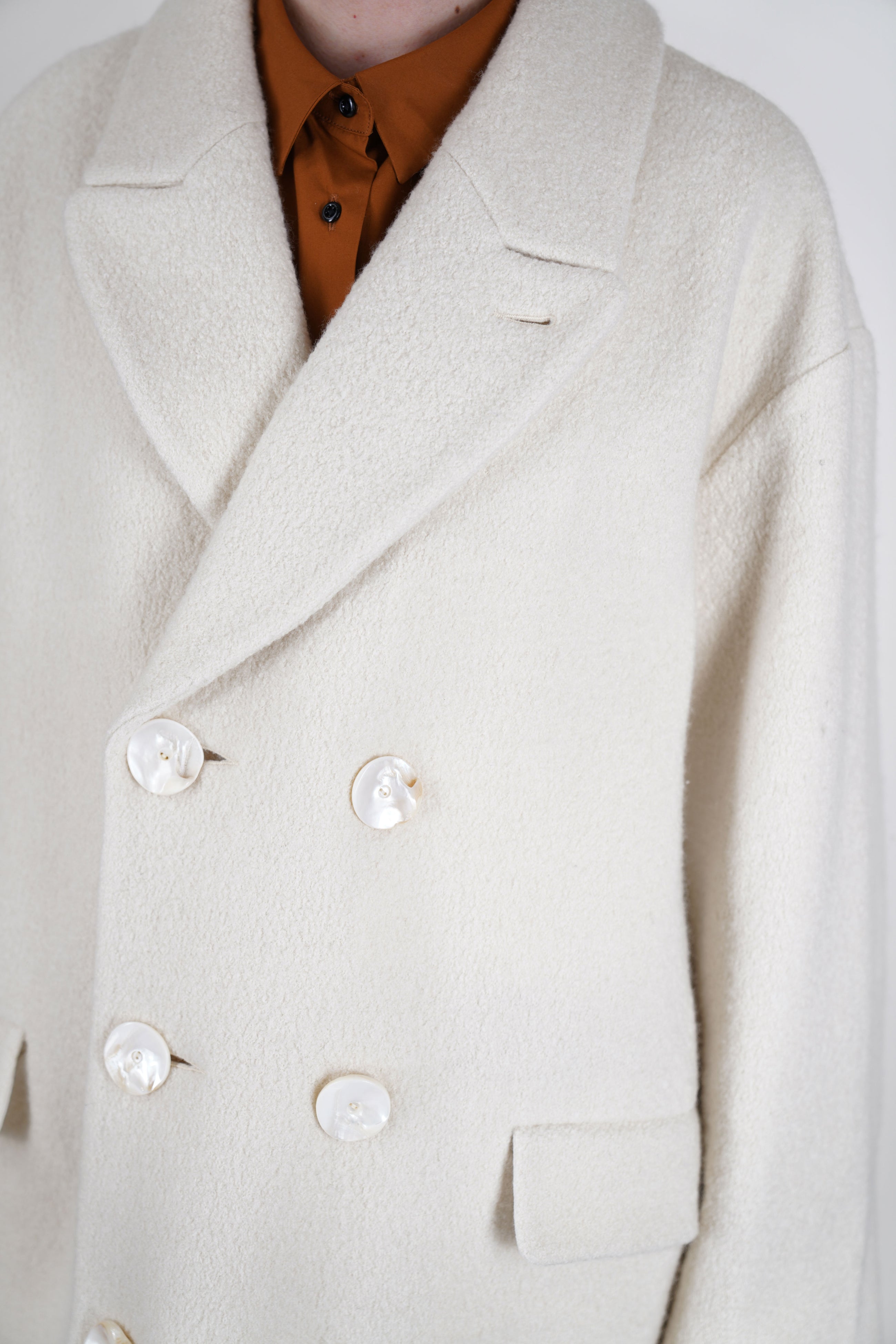 detail view of école de curiosités coat claus boiled wool ecru crafted from premium boiled wool for a sophisticated finish.