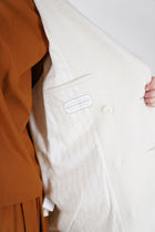 detail view of inside striped lining of école de curiosités coat claus boiled wool ecru