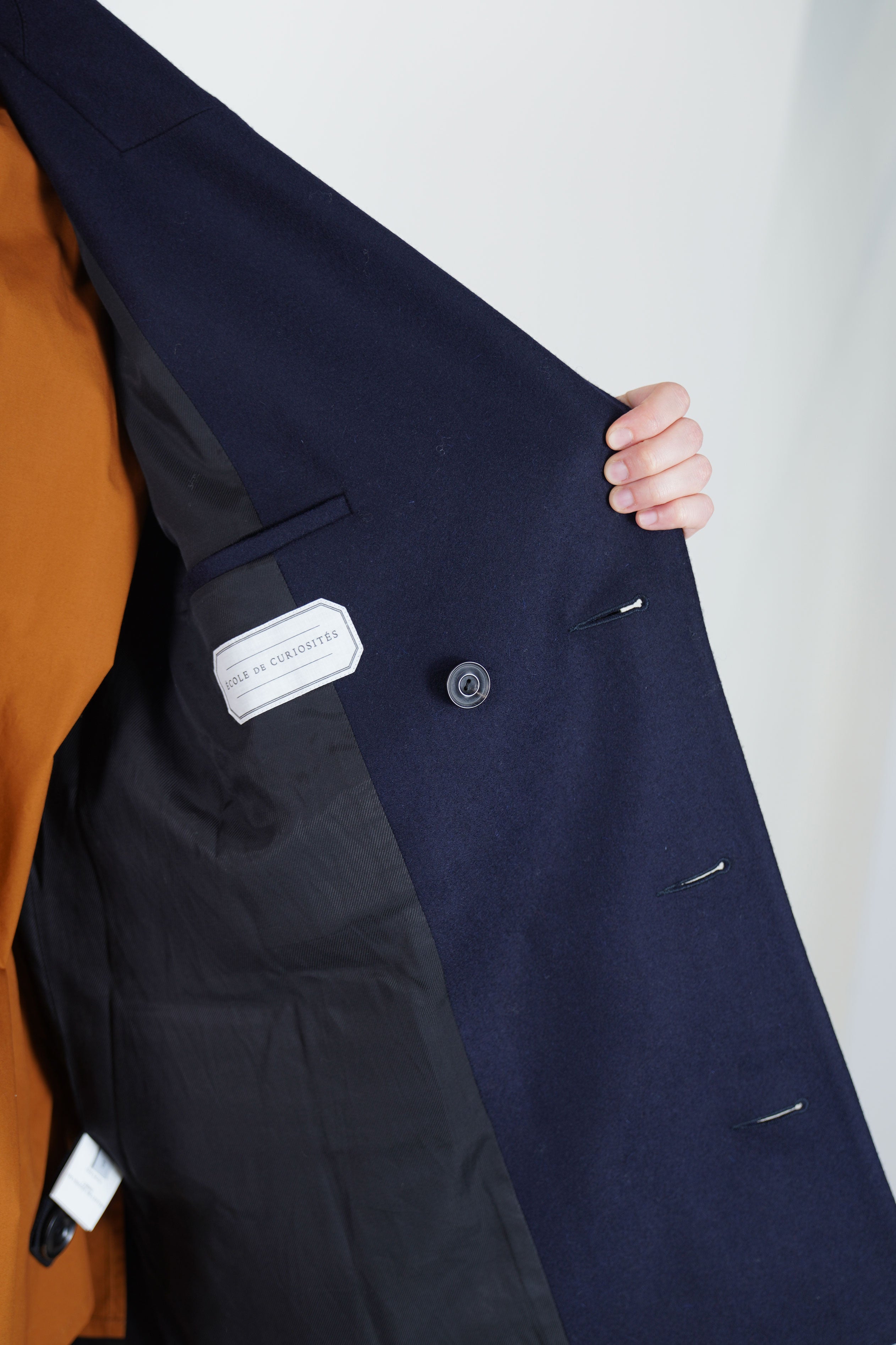 detail view of inside smooth lining of école de curiosités claus coat loden wool dark navy