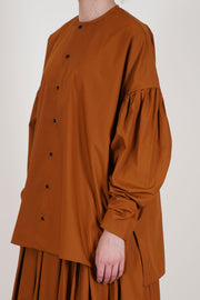 école de curiosités shirt basil caramel brown offers a relaxed silhouette with a round neckline and button-front closure.